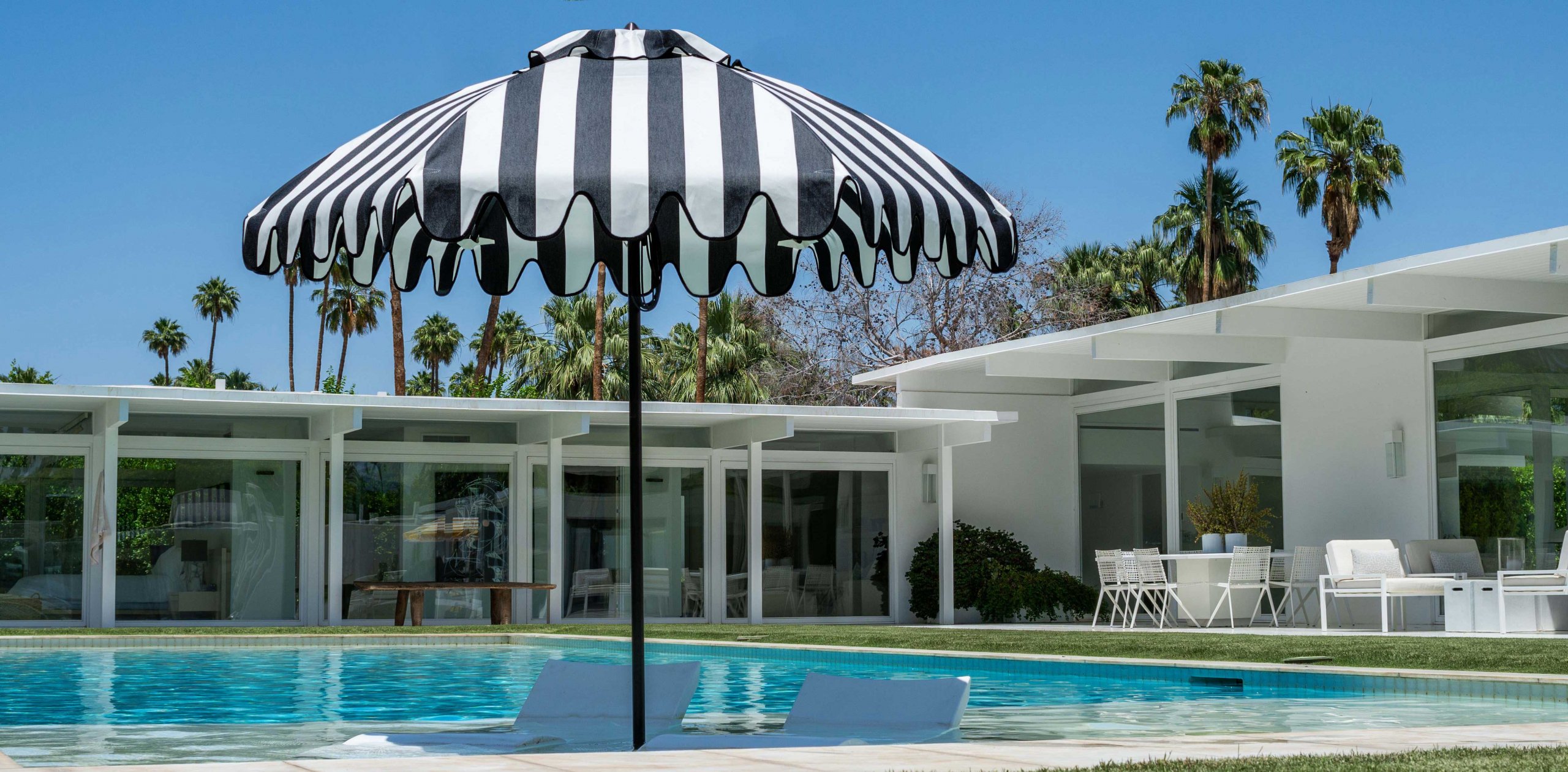 Image of umbrella in pool with chaises
