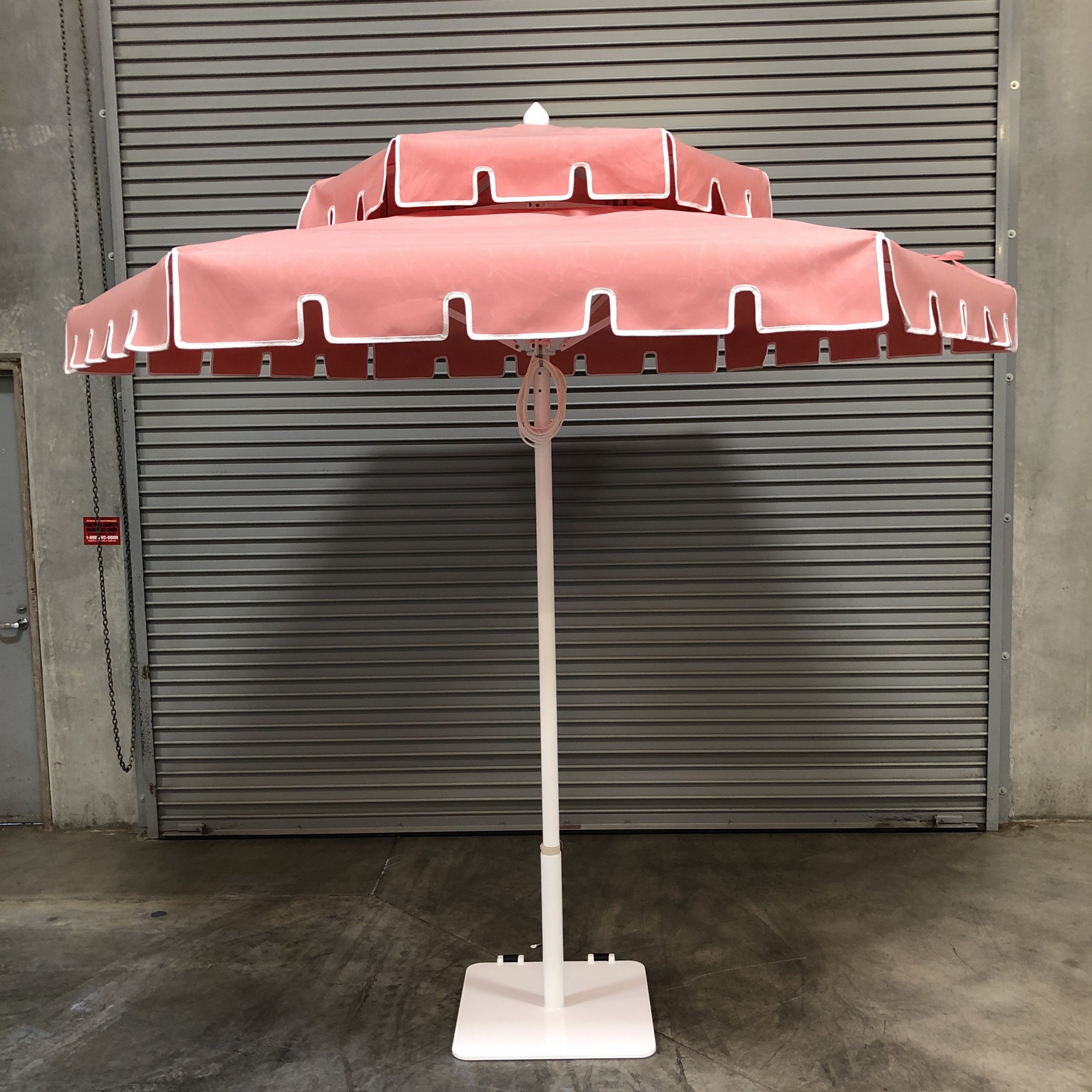 Image of pink umbrella in front of warehouse door